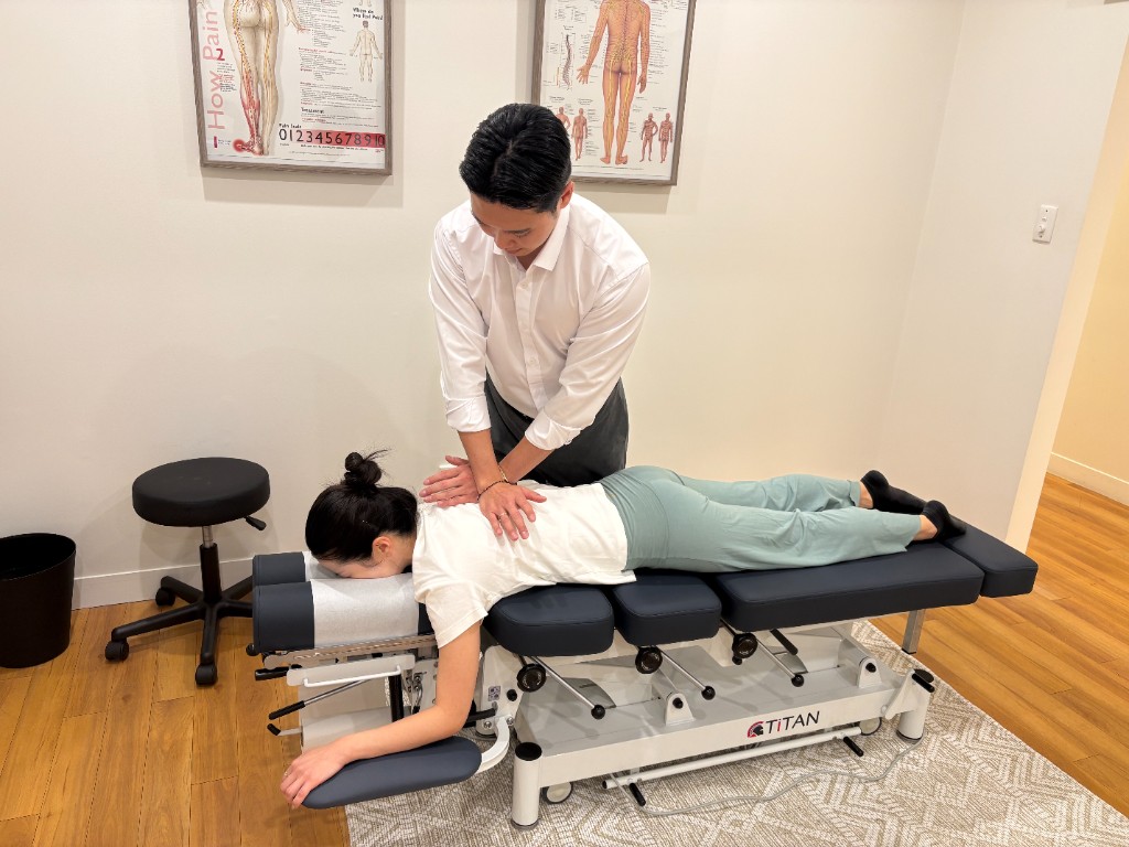 Chiropractor providing a spinal adjustment on a treatment table